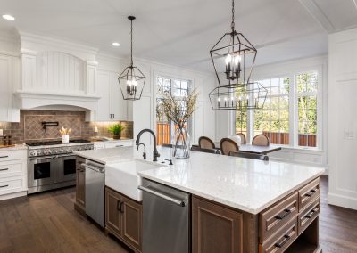 Luxury kitchen with white quartz counters, hardwood floors and stainless steel appliances